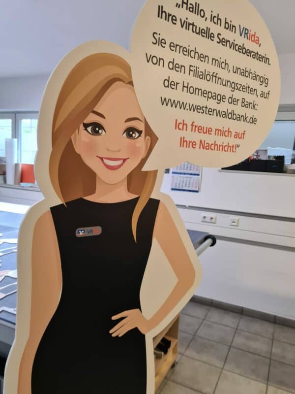 Ein großer Aufsteller einer blonden Frau im dunklen Kleid weißt auf die neue Chatfunktion der Westerwaldbank hin.